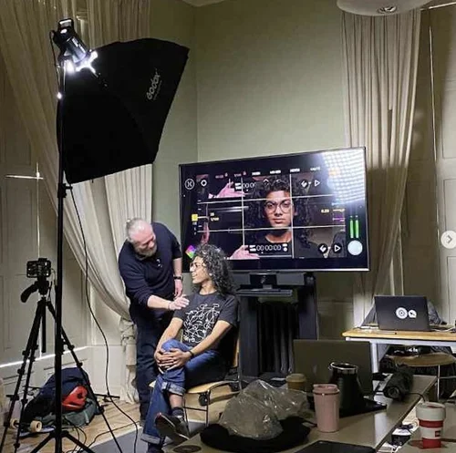 A man speaks to a young women on a TV set.